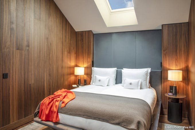 Chambre à l'hôtel Jiva Hill au lit entre deux murs plaqués de bois.