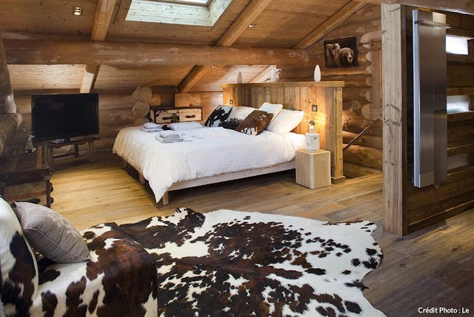 Chambre en bois à la décoration cosy au chalet de luxe Le Lodge des Sens.