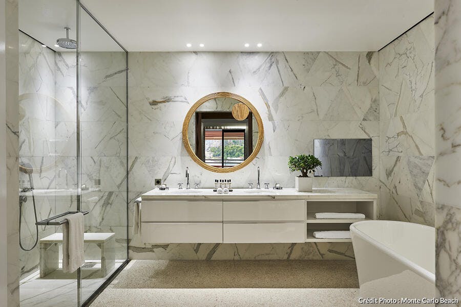 Grès grande salle de bains en marbre avec miroir rond doré.