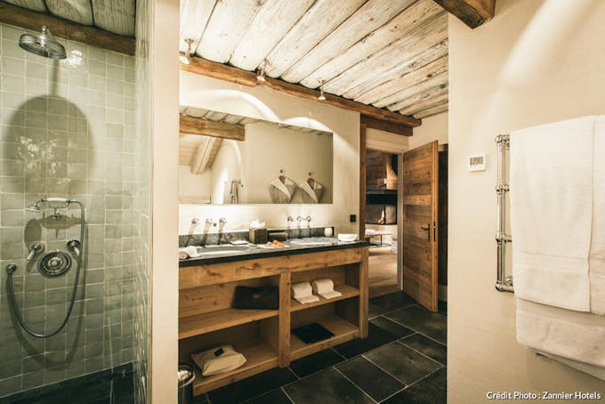 Salle de bains d'une suite spacieuse avec baignoire et décor en bois.