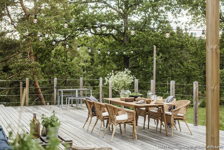 Terrasse en bois et guirlandes lumineuses tout autour de la table. Le dîner est prêt et la soirée peut battre son plein !