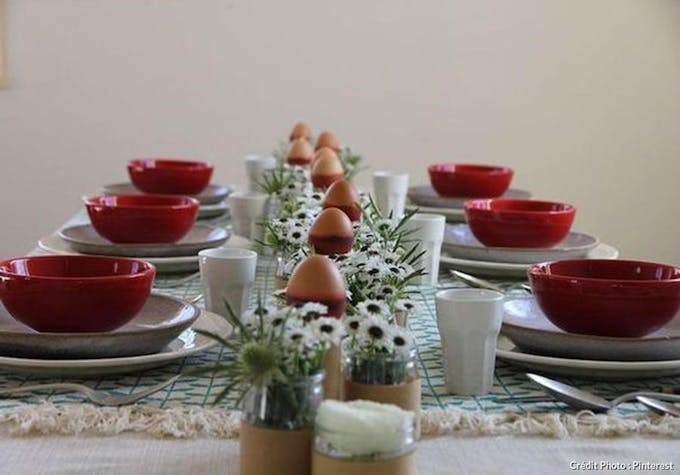 Table avec plusieurs assiettes, des fleurs et des oeufs