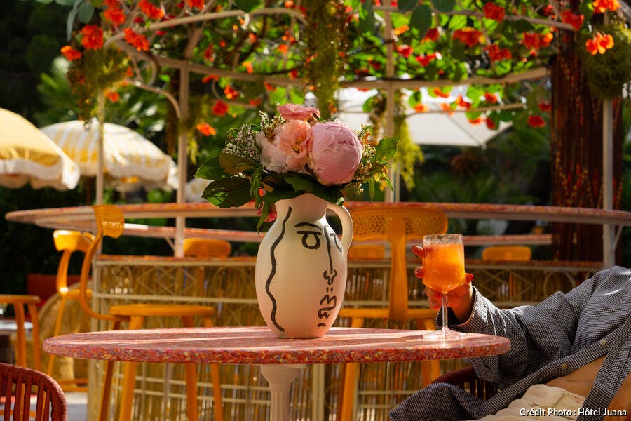 Pichet vase style Picasso sur table à l'extérieur au PASEO avec fleurs.