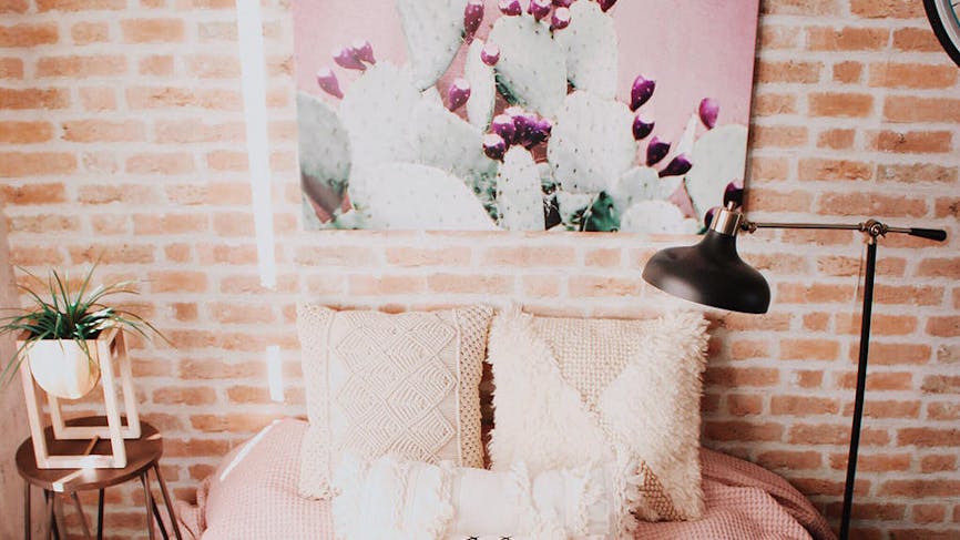 Chambre de style bohème avec mur de briques roses