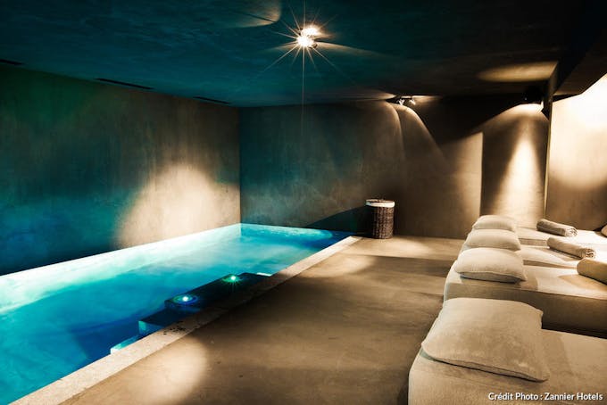 Spa avec piscine intérieure d'eau turquoise en souterrain au chalet Zannier. 