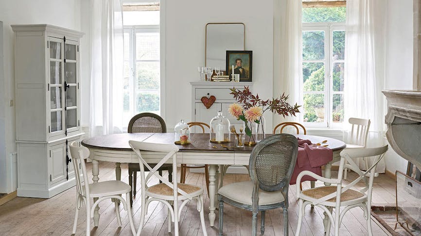 Une salle à manger de style campagne et arty avec des chaises dépareillées