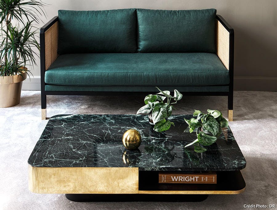 Un canapé en velours et une table en marbre vert