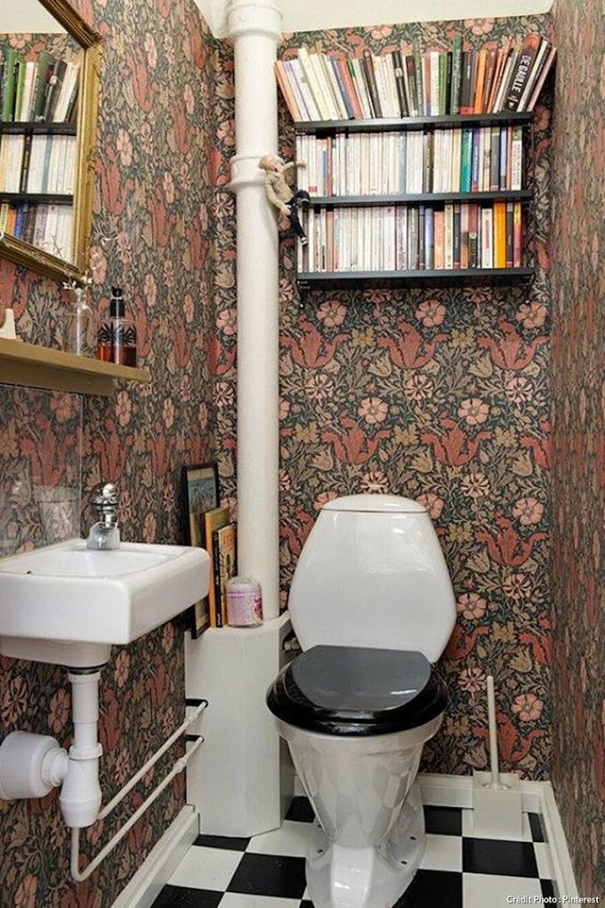 Toilettes vintages avec du papier peint et un sol damier 