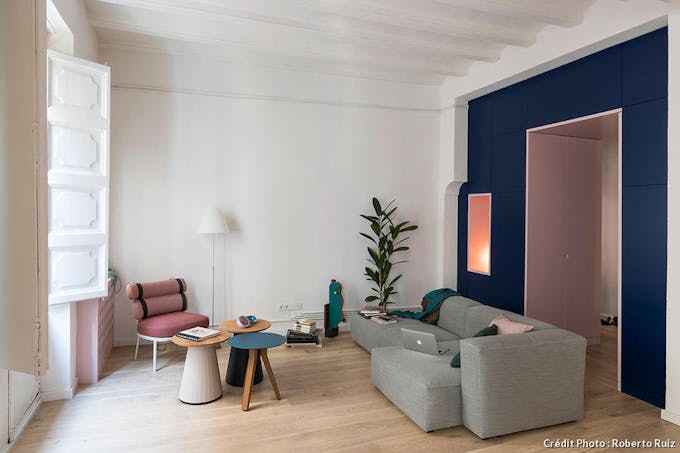 Un salon moderne rose et bleu à l'architecture graphique  