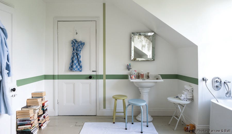 Mur et porte de salle de bains customisés avec des traits verts.