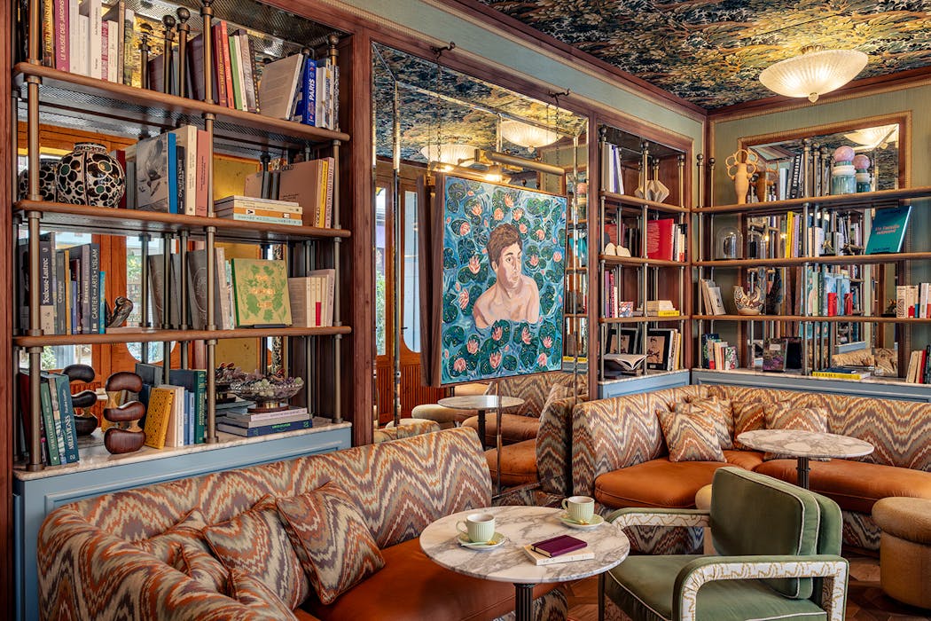 un salon d'hôtel parisien cosy avec bibliothèque et canapés XXL