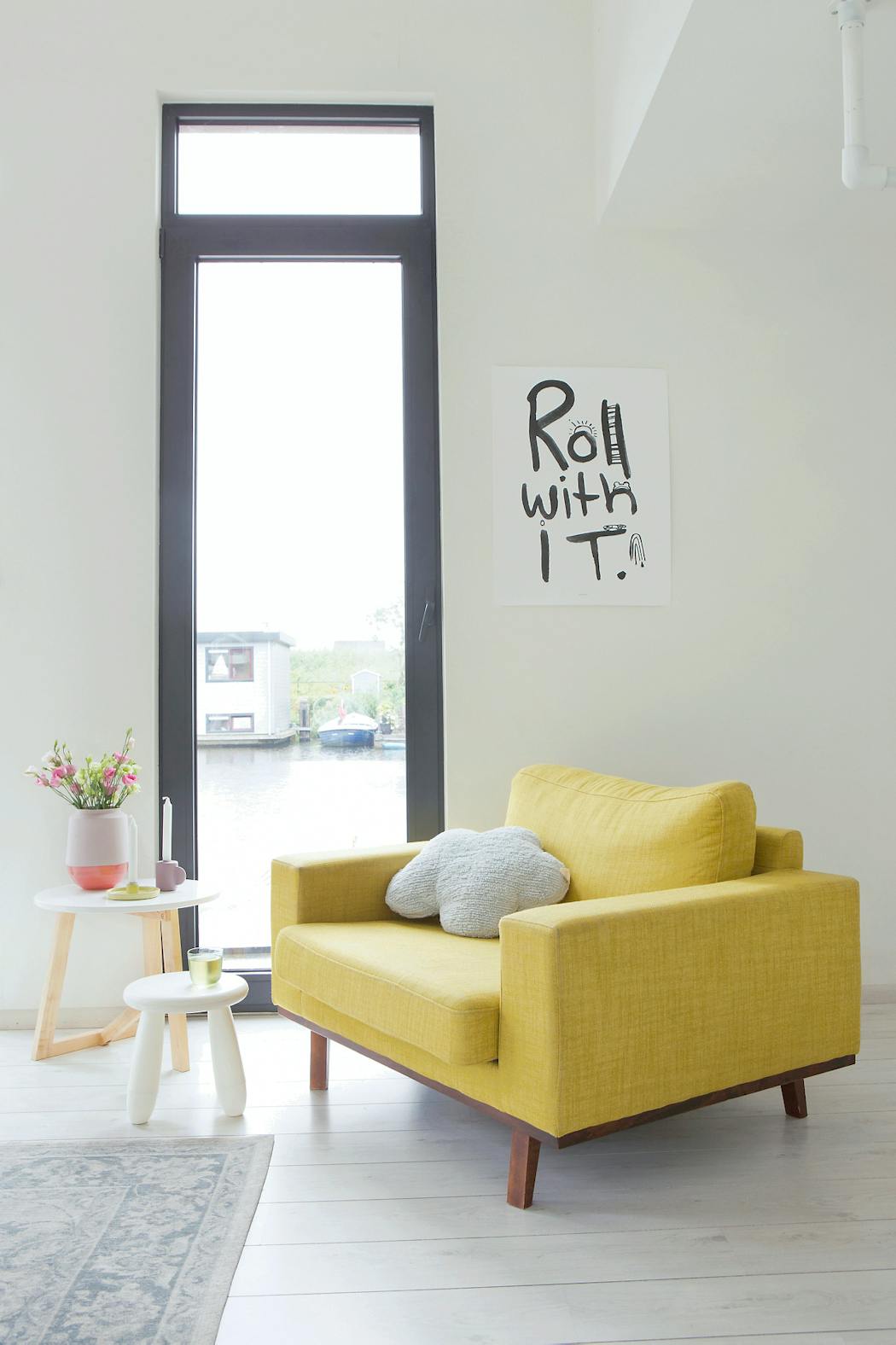 Large fauteuil jaune style design et vintage et fenêtre verticale avec affiche graphique noire et blanche