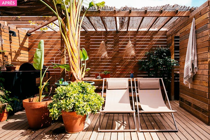 Une terrasse aménagée en coin détente avec plantes, barbecue et bois