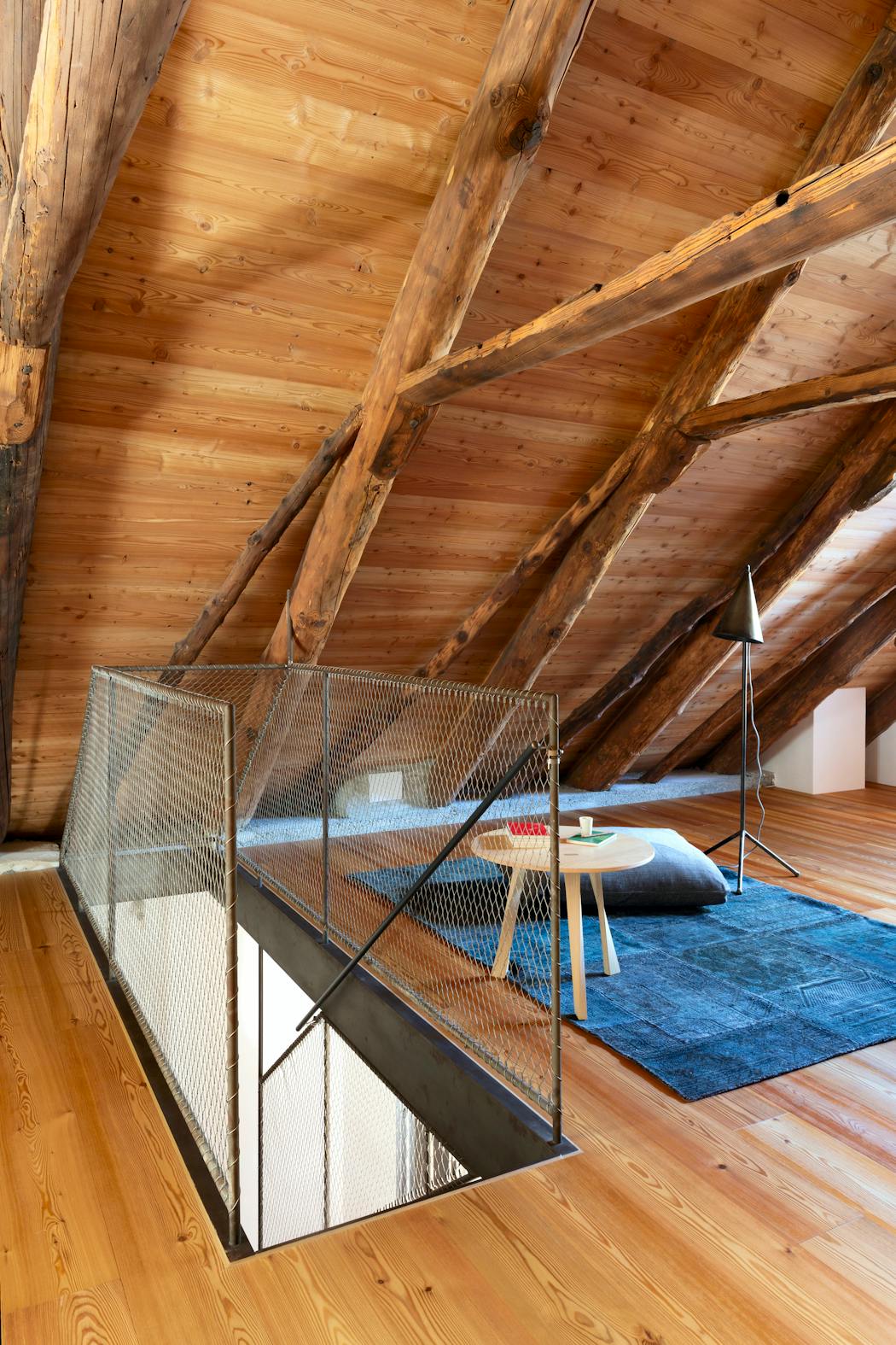 Salle zen sous les toits avec charpente en bois.