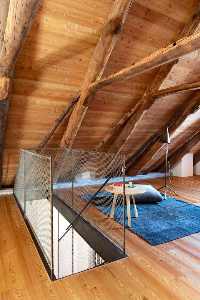 Salle zen sous les toits avec charpente en bois.