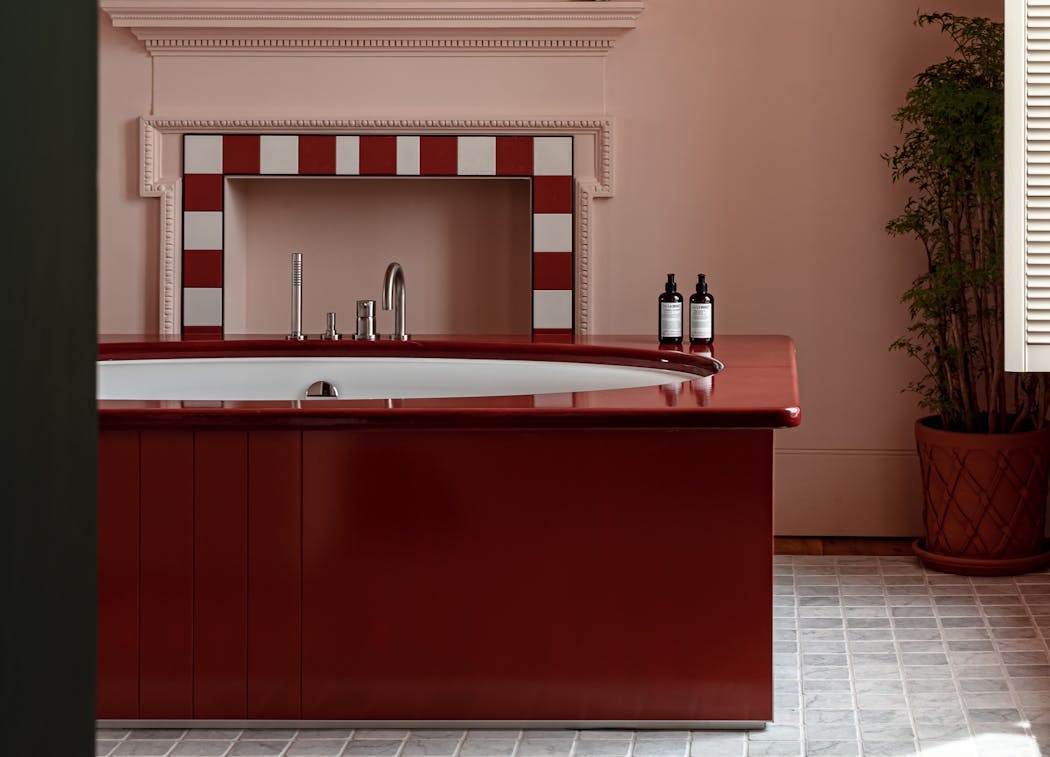 Une baignoire rouge laquée dans une maison de campagne